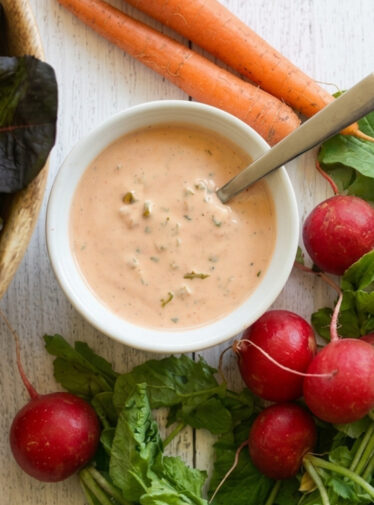 Russian dressing in a bowl near salad components