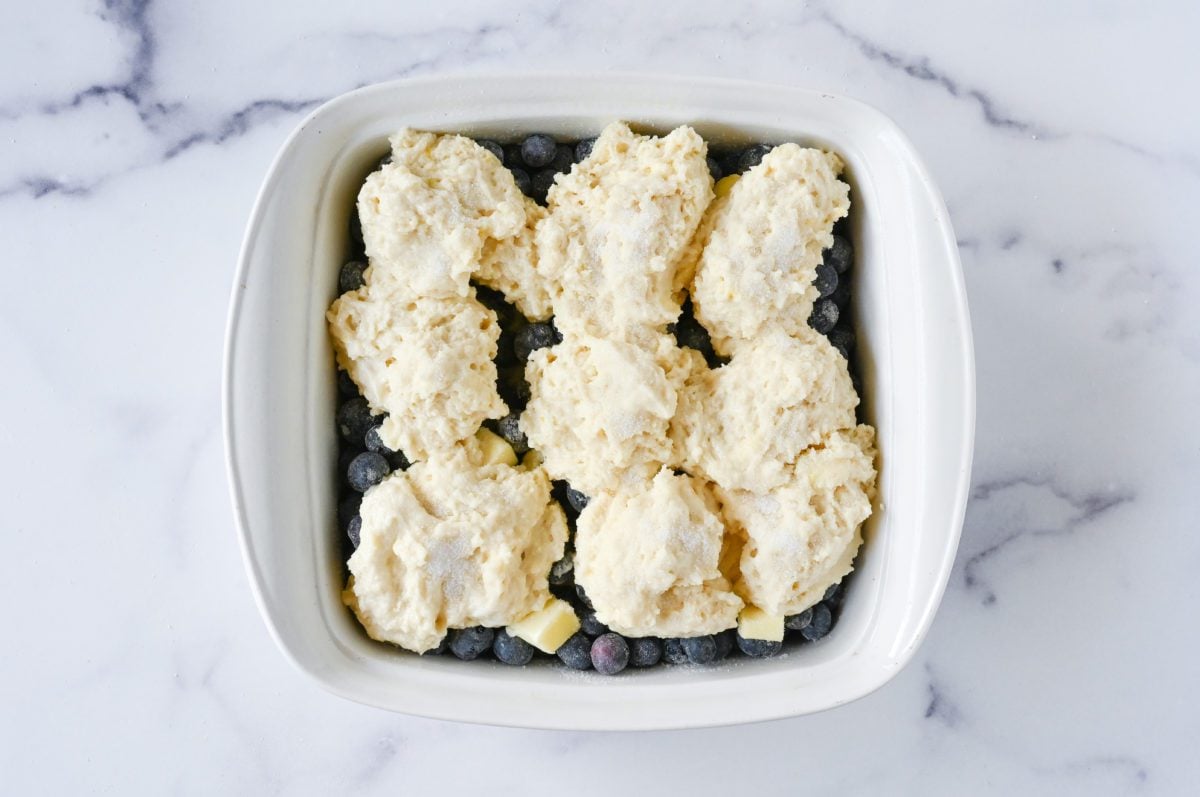 dolloped biscuit topping on top of blueberry mixture