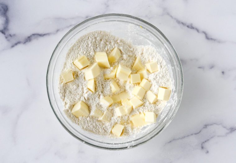 adding cubes of cold butter to biscuit topping