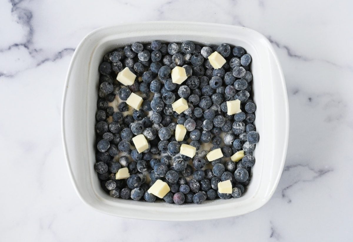 blueberries in baking dish topped with butter