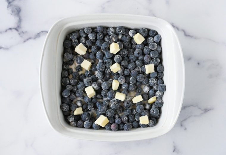 blueberries in baking dish topped with butter