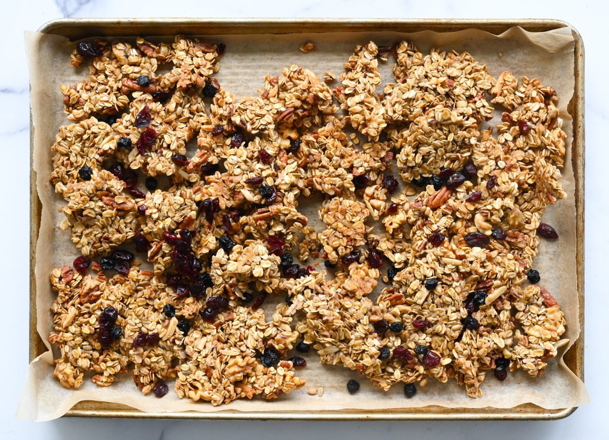 Granola on a lined baking sheet.