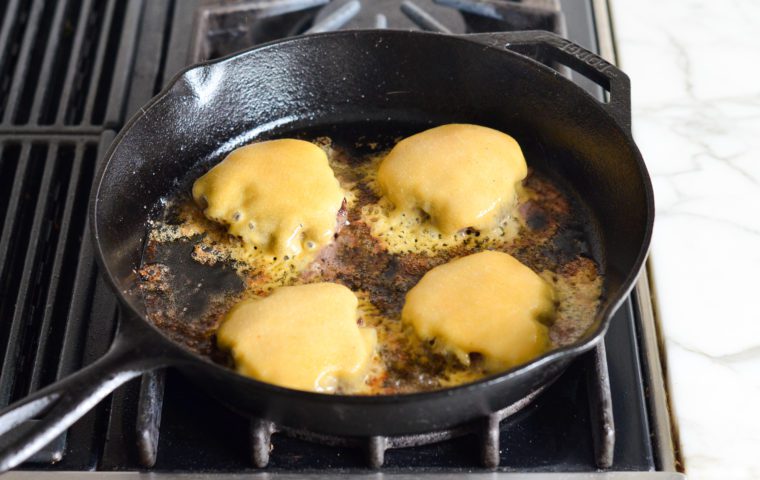cheese melted over burgers in skillet