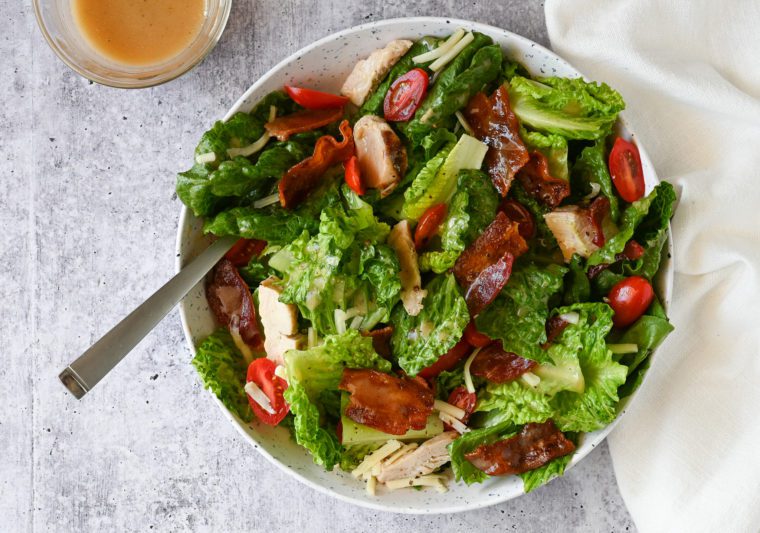 Fork in a bowl of BLT salad with chicken.