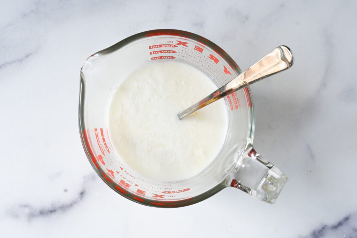 Spoon in a measuring cup of buttermilk.