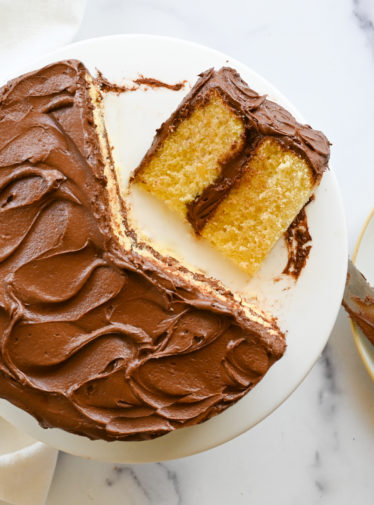 Partially-served yellow cake with rich chocolate buttercream.