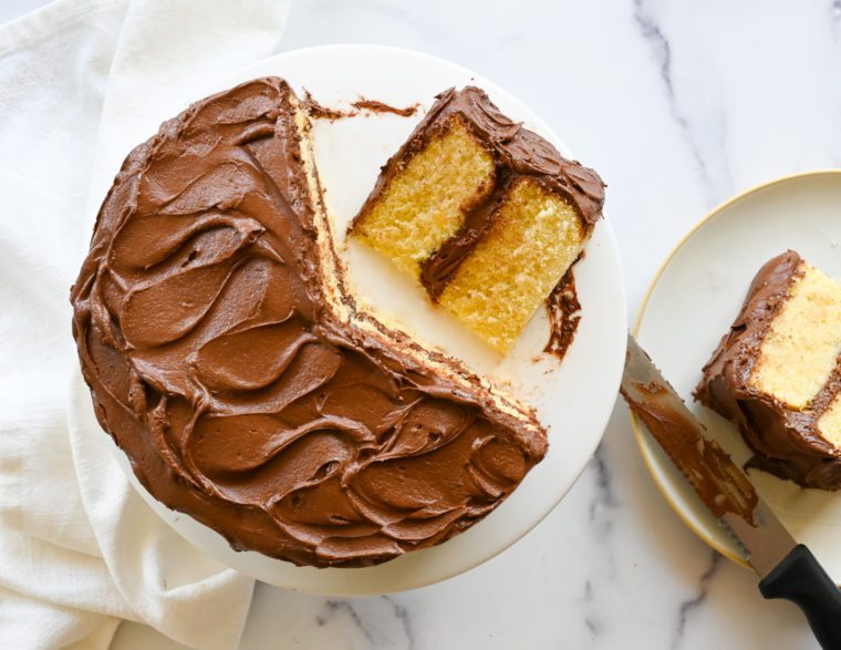 Partially-served yellow cake with rich chocolate buttercream.