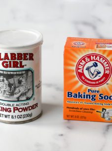 Container of baking powder next to a box of baking soda.