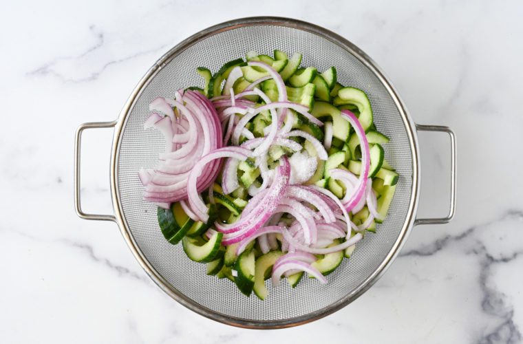 salting cucumber and onion in strainer