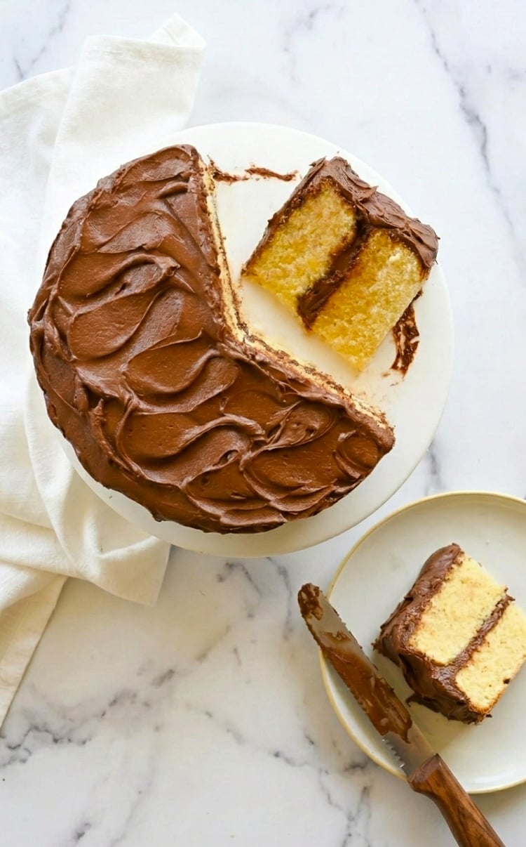 Sliced yellow cake on cake stand.