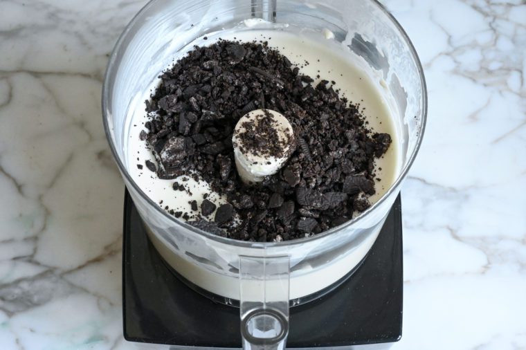 mixing oreo crumbs into cheesecake ice cream base
