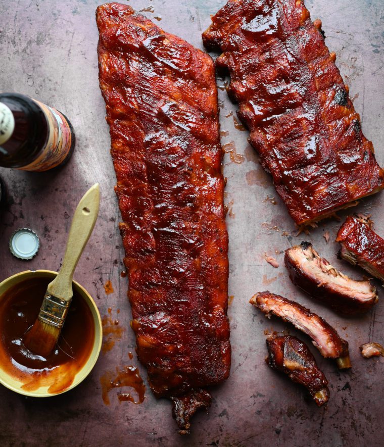 Bowl of barbeque sauce with baby back ribs.