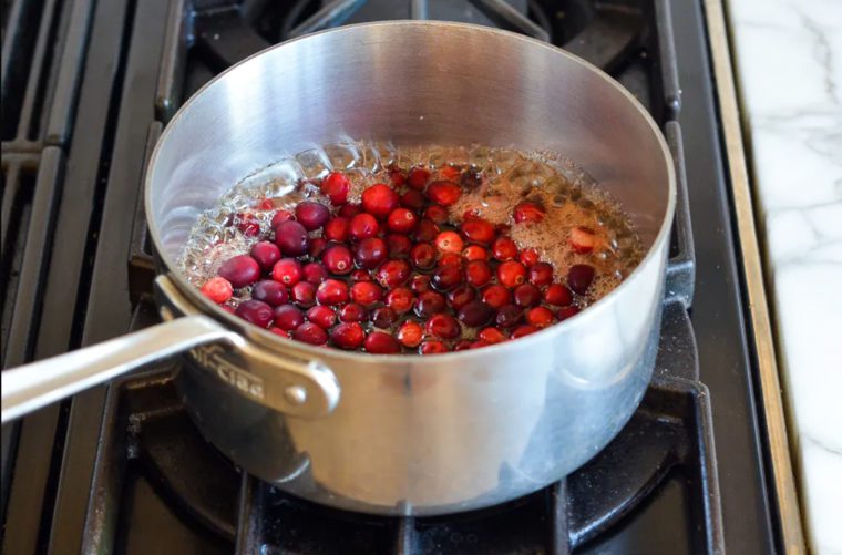 Cranberries boiling in a medium saucepan.
