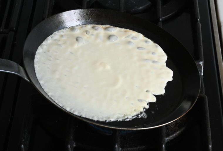 swirling the crepe batter around the pan