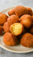 Pile of hush puppies, one of which is missing a bite.