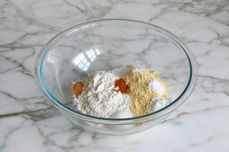 flour, cornmeal, sugar, salt, baking powder, baking soda, and spices in bowl
