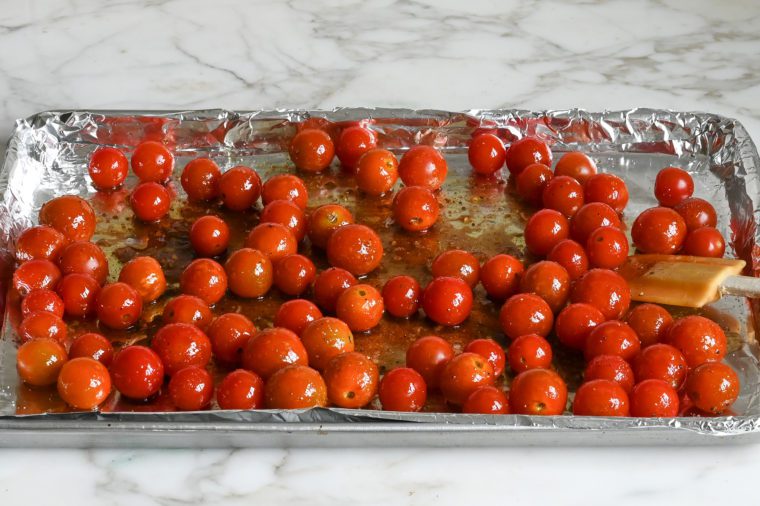 cherry tomatoes tossed with oil, vinegar, garlic and seasoning and ready to roast