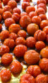 Roasted cherry tomatoes on a lined baking sheet.
