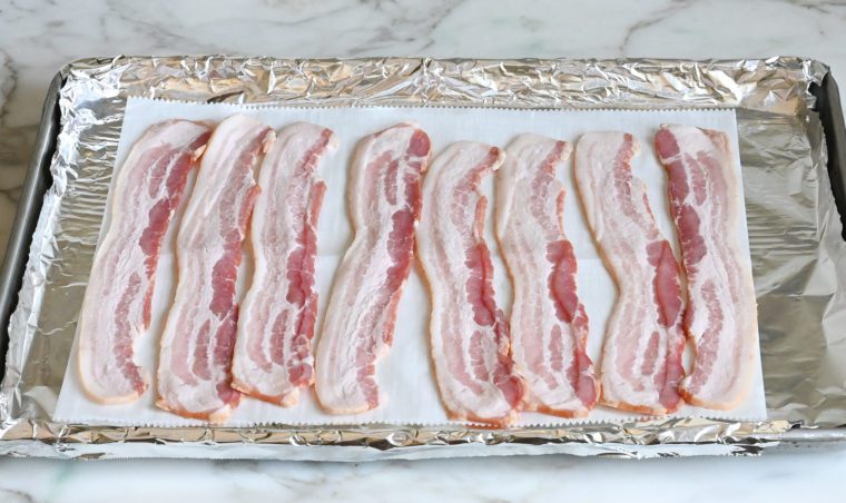 bacon on foil and parchment-lined baking pan