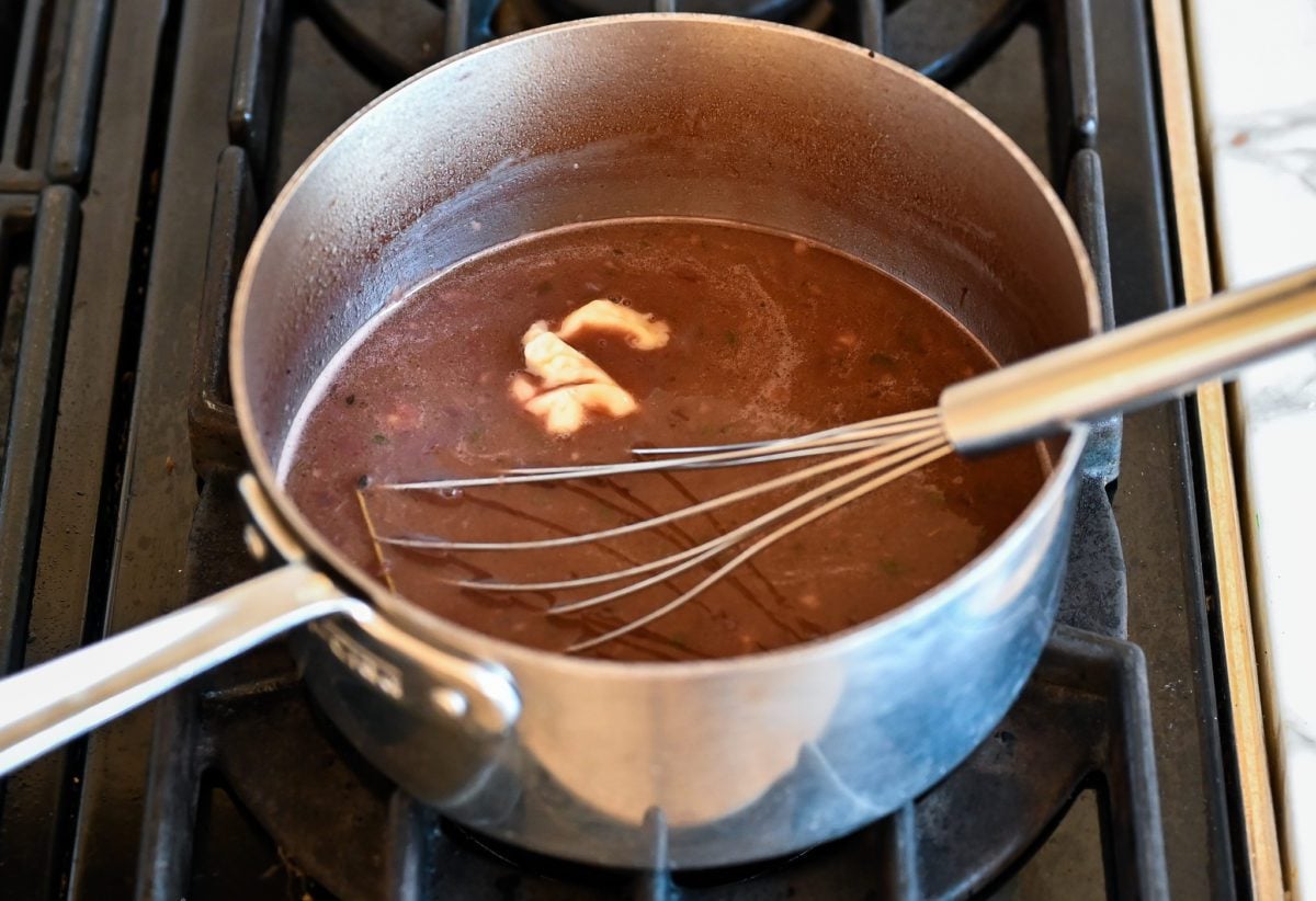 whisking the flour and butter paste into the sauce
