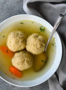 Spoon in a bowl of matzo ball soup.