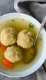 Spoon in a bowl of matzo ball soup.