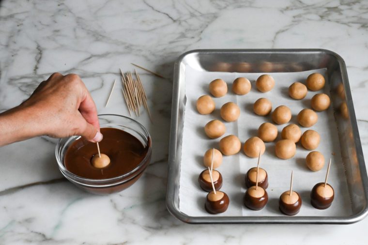 dipping buckeyes in melted chocolate