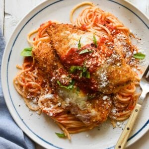 plate of chicken parmesan over spaghetti