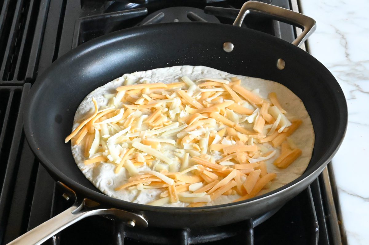 cheese spread over tortilla in skillet