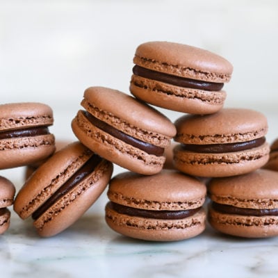 chocolate macarons stacked on white marble