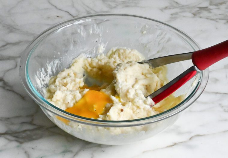 adding egg yolks to potatoes
