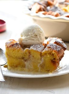 Piece of bread pudding on a plate with a spoon.