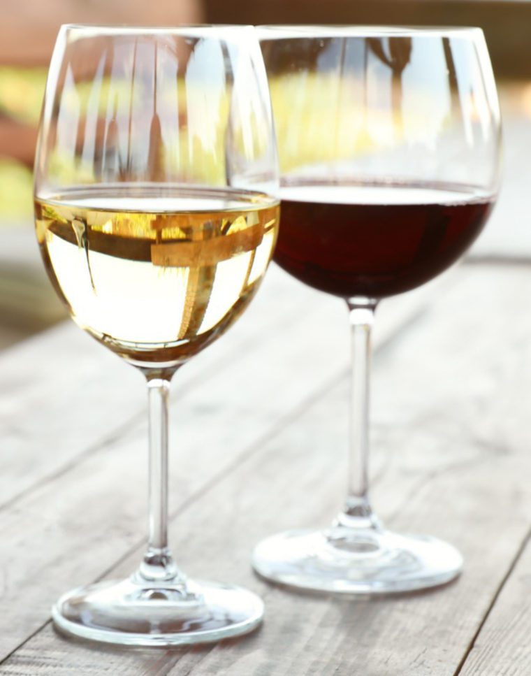 Glass of white wine next to a glass of red wine.