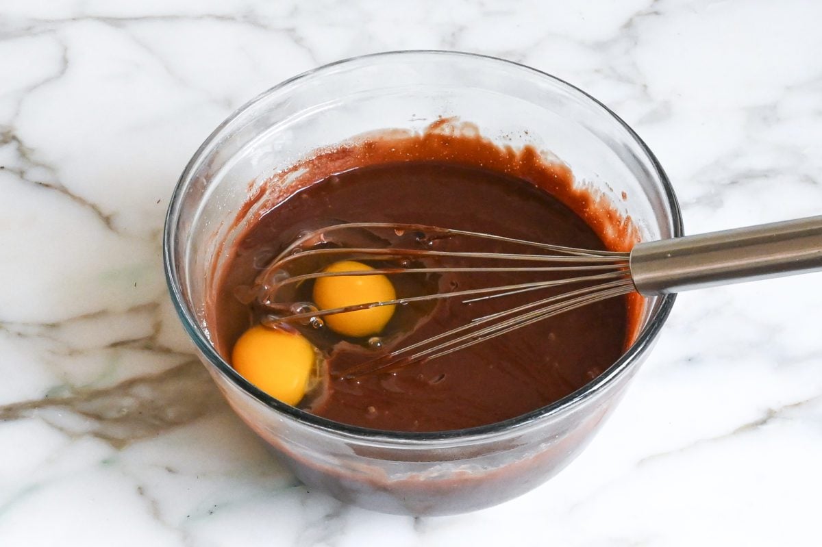 Adding the eggs and vanilla to the chocolate mixture.