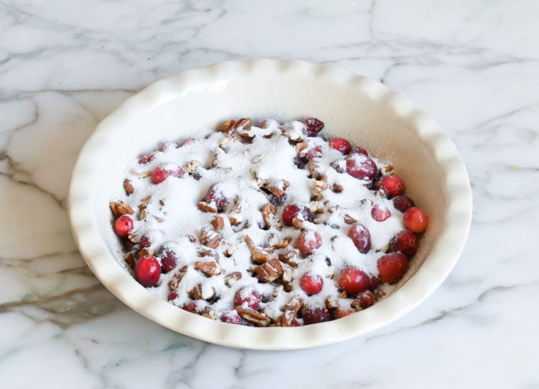 sprinkling sugar over cranberries and pecans