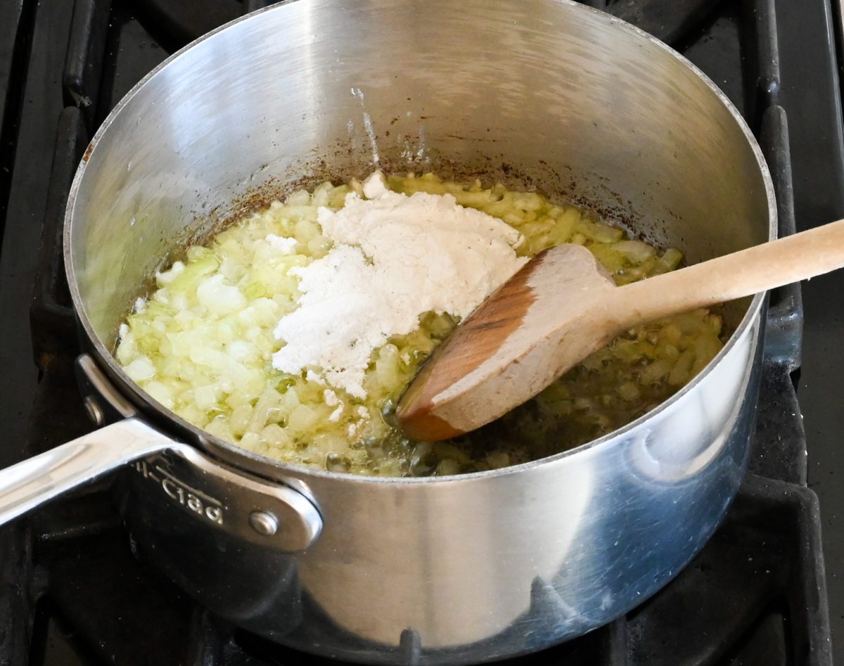 adding the flour to the onion mixture.