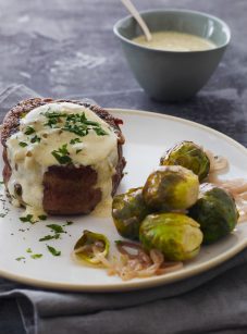 steak au poivre on plate with cognac sauce and Brussels sprouts
