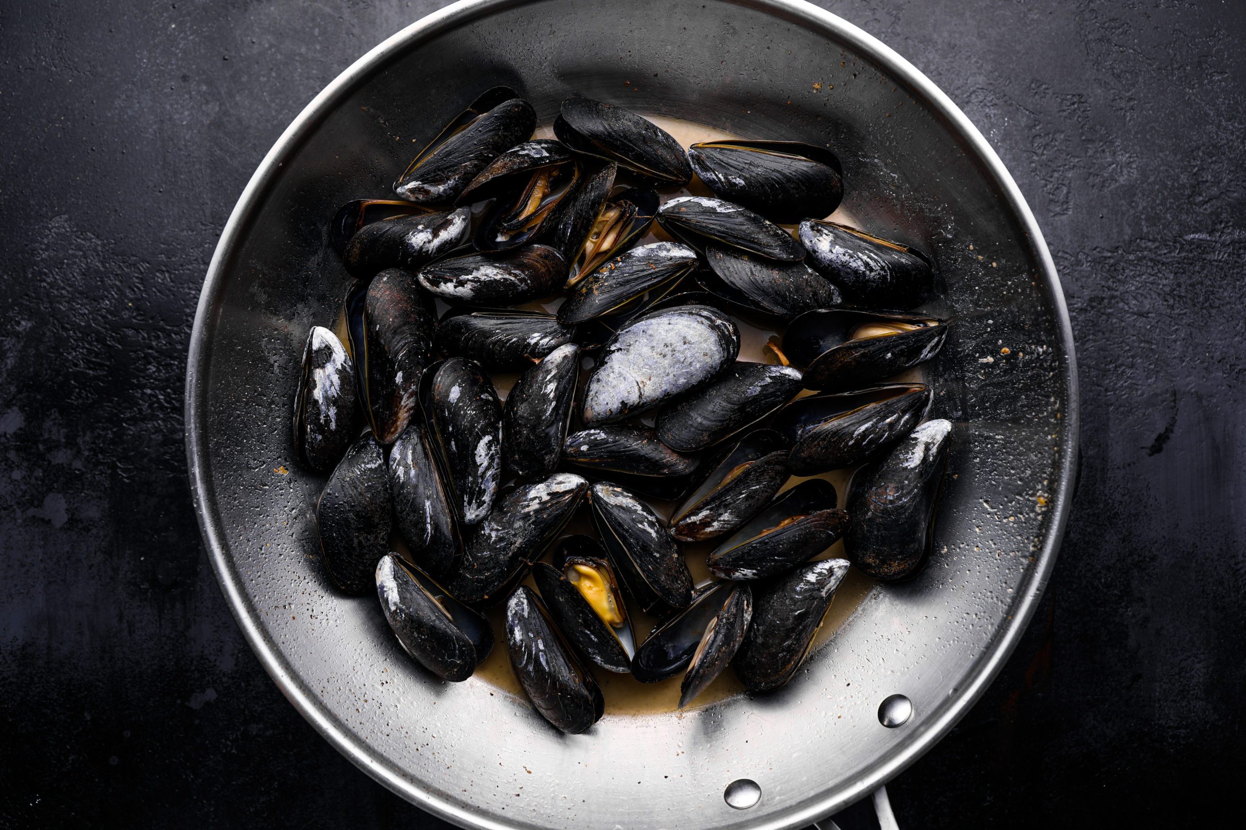 Cooked mussles in a skillet.