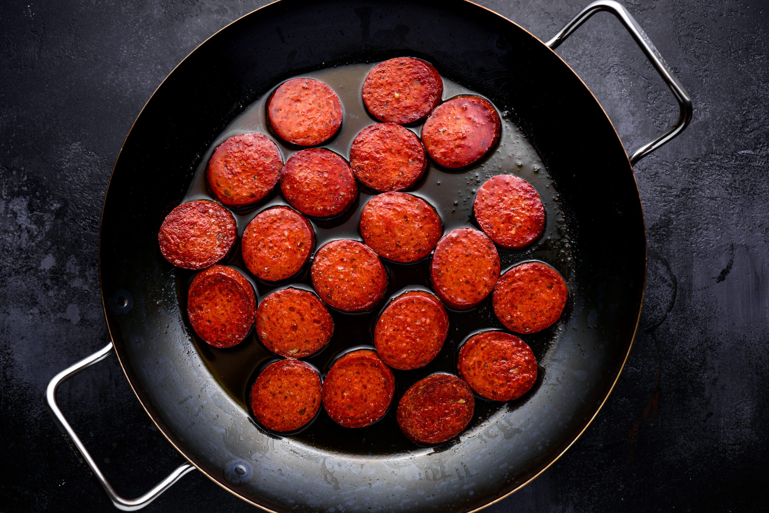 Chorizo cooking in a pan.