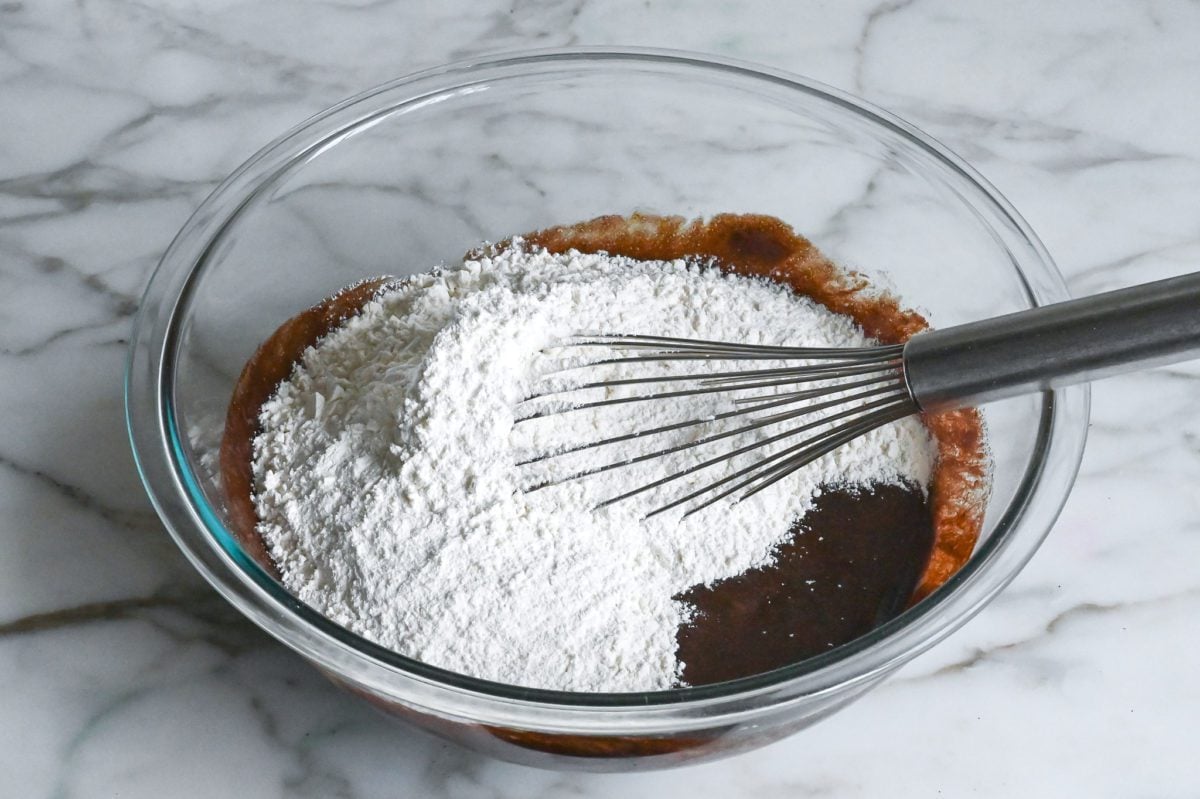adding the flour mixture to the chocolate crinkle cookie dough