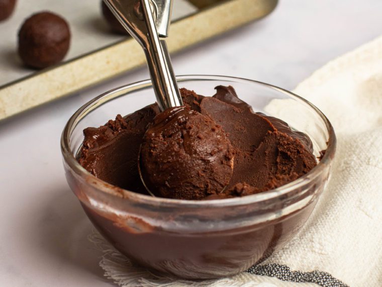 Ice cream scoop in a bowl of chocolate ganache.