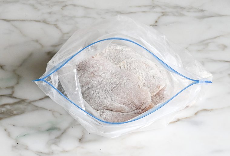 chicken in bag coated with flour and seasoning