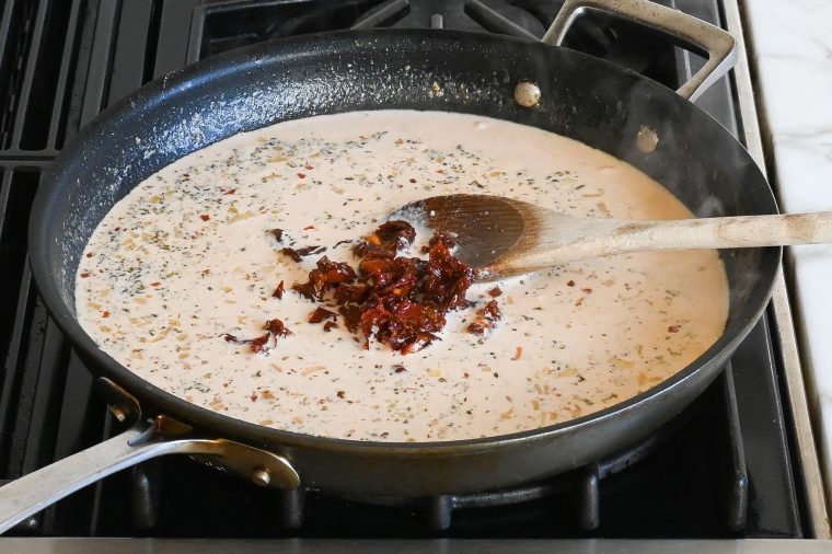 cream, chicken broth, tomato paste, seasoning, and sun-dried tomatoes in skillet