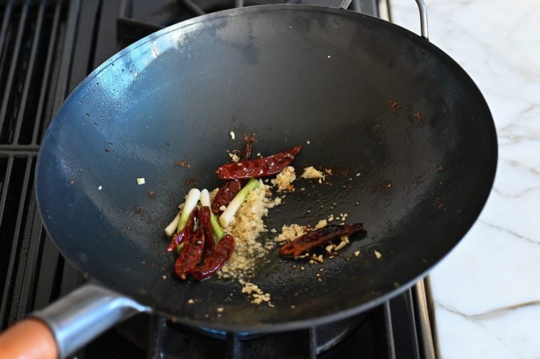 cooking ginger, red peppers, garlic, and white scallions