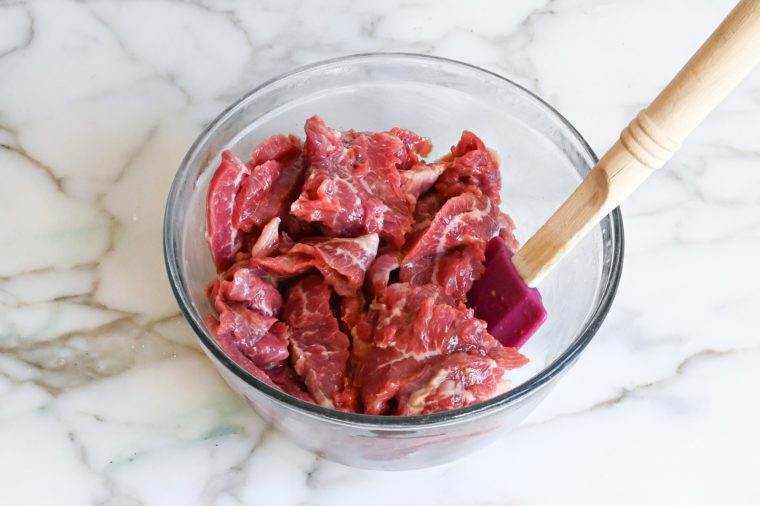 slices of flank steak marinating in bowl