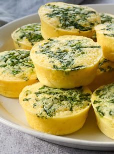 Spinach egg bites piled on a plate.