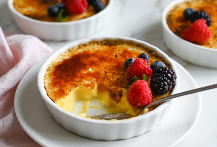 Spoon in a partially-eaten creme brulee.