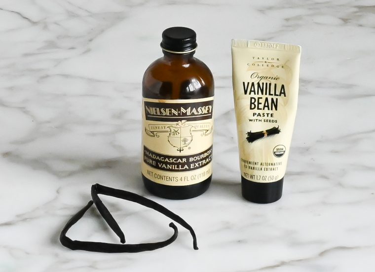 Vanilla beans, extract, and paste on a counter.