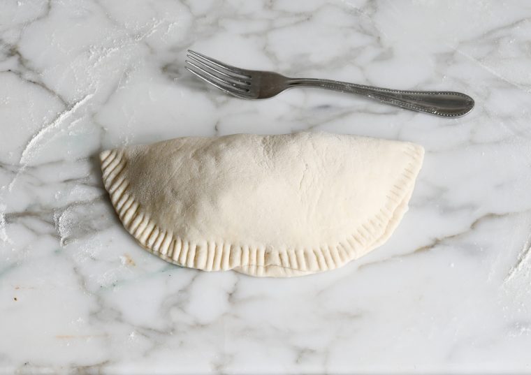 edges of calzone pressed with a fork