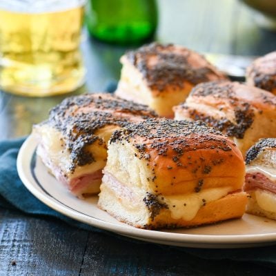 Ham and cheese sliders on a plate.